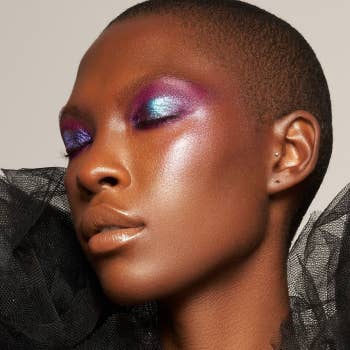 model wearing blue, pink, and purple pigment on their eyelids