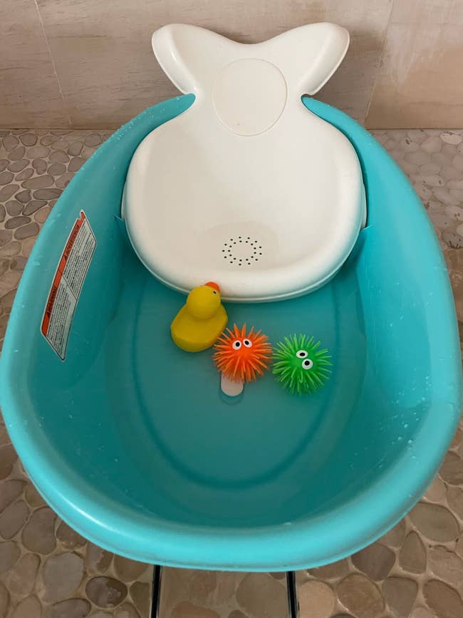 The blue whale tub with toys in the shower