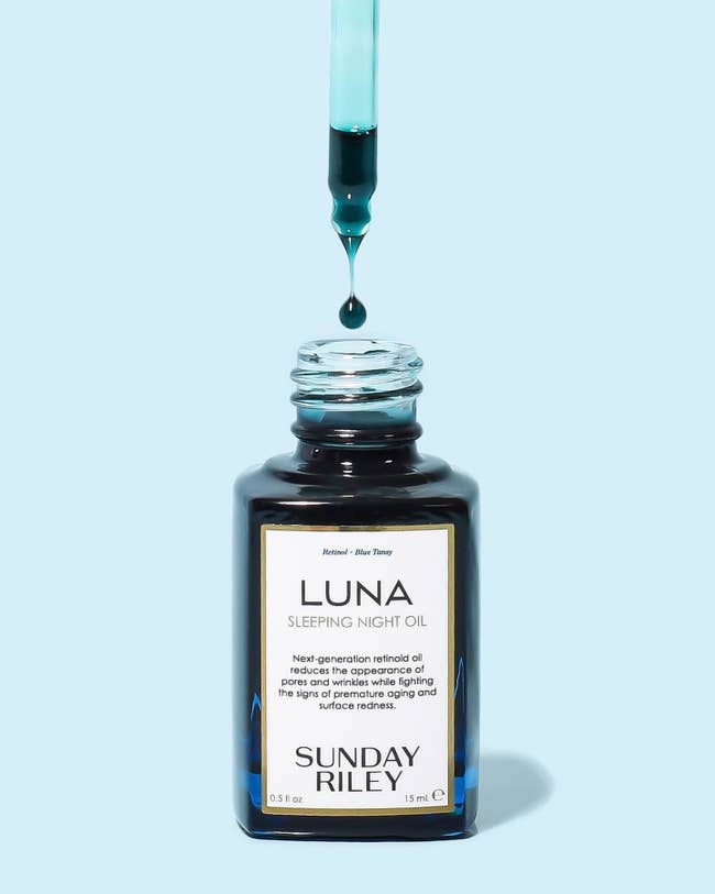 the bottle of Sunday Riley Luna sleeping night oil with a dropper above it, showing the blue oil
