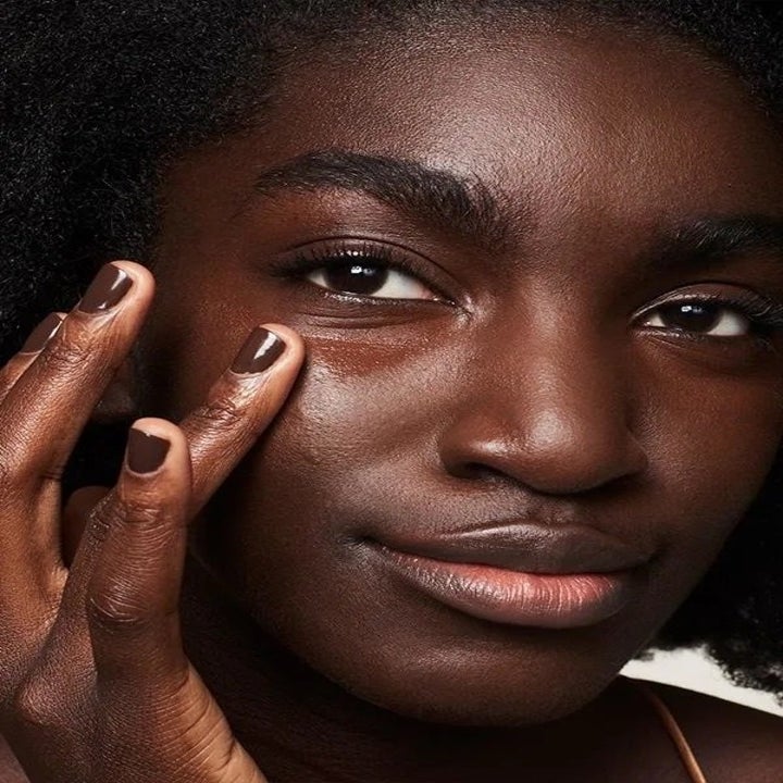 model applying the concealer to their face