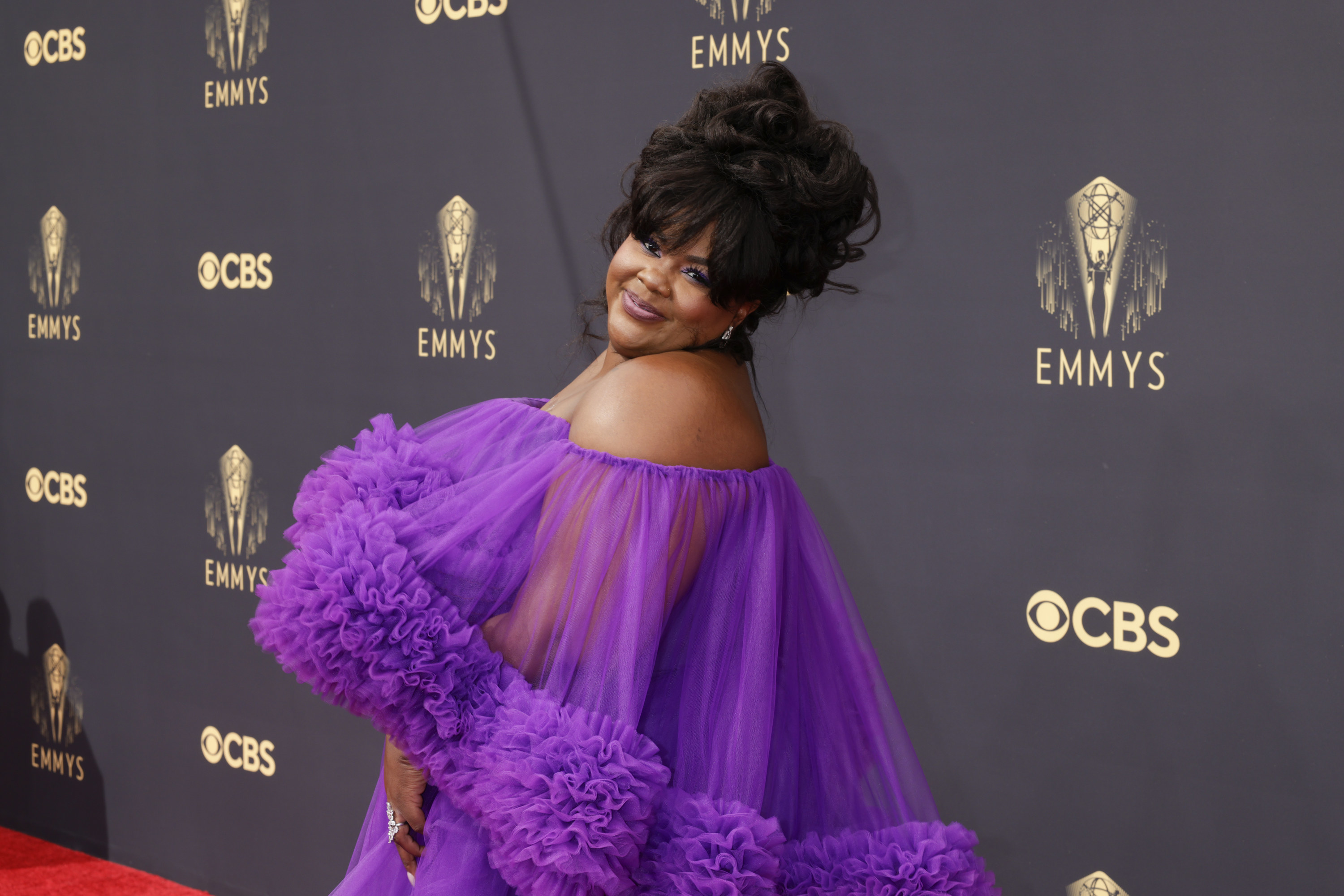 Nicole Byer poses on the Emmys red carpet