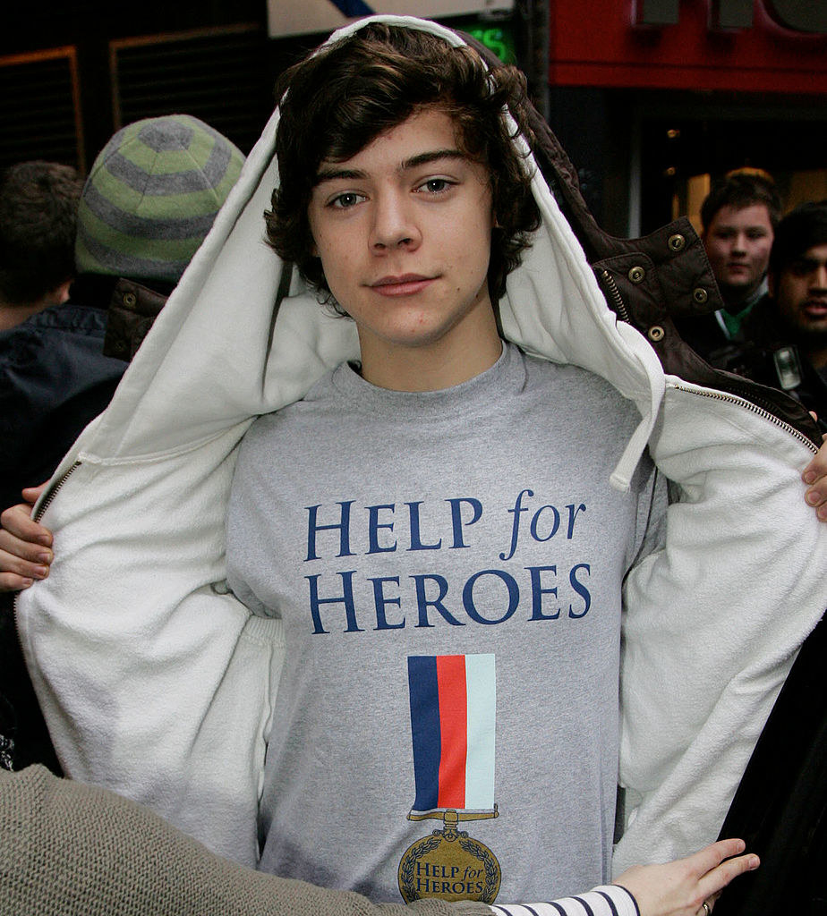 he is wearing a help our heroes shirt and a hoodie