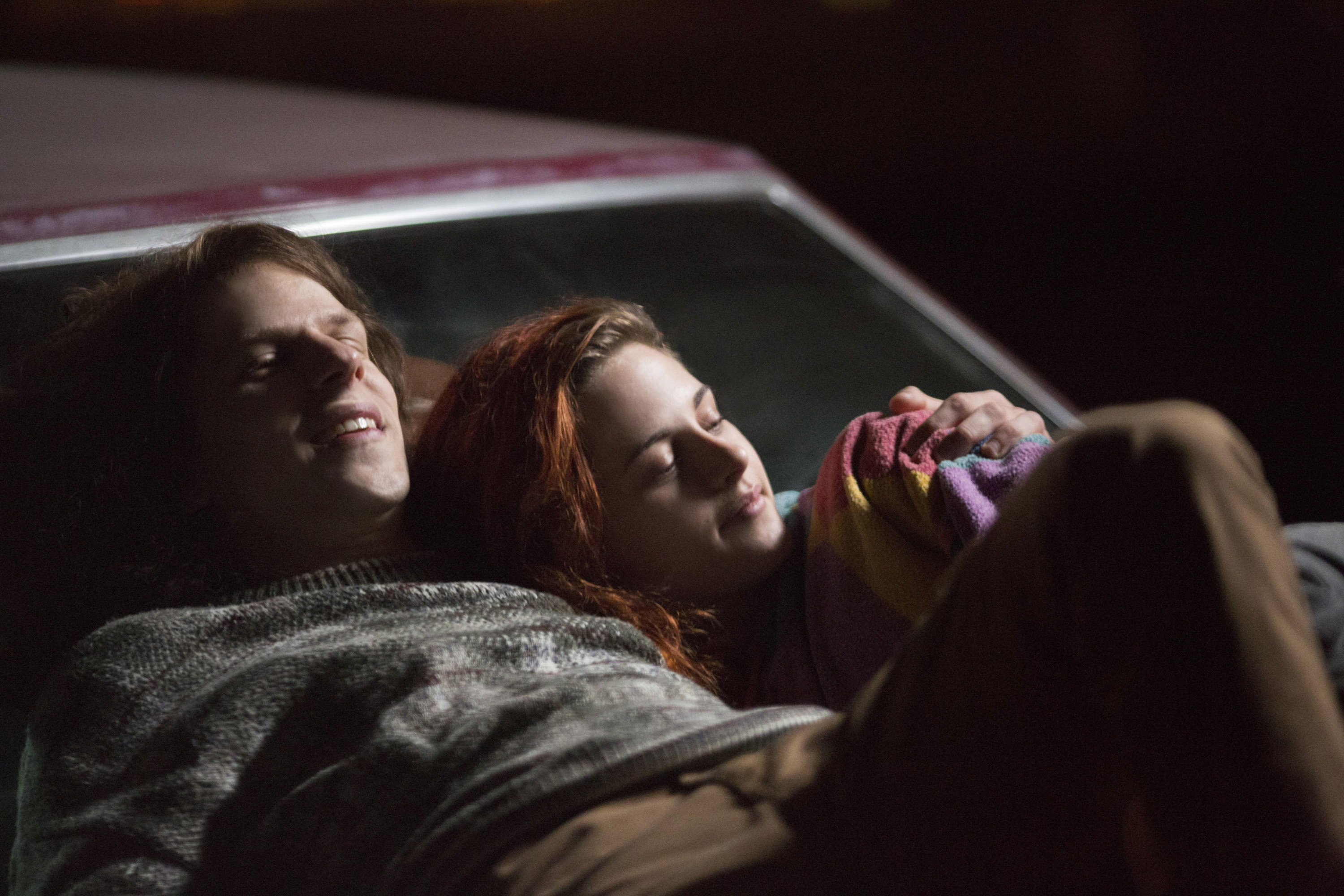 杰西·艾森伯格和克里斯汀·斯图尔特躺在一辆汽车的引擎盖在美国超