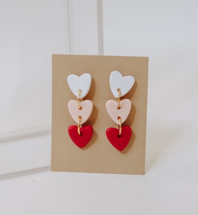 The pair of dangling heart earrings with white, pink, and red hearts