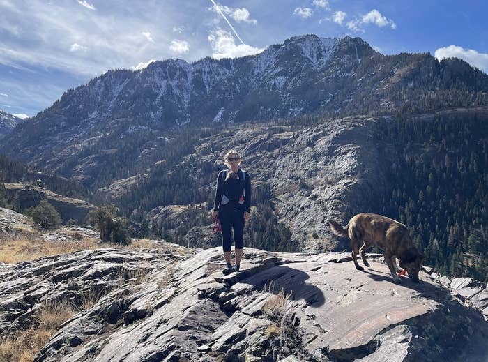 Woman with a baby stands near a mountain