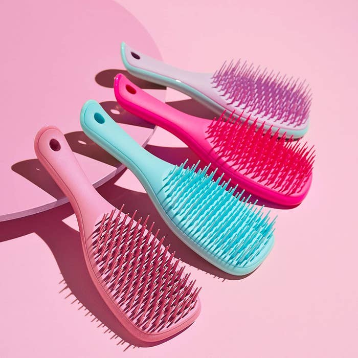 A group of four brushes propped up on a colourful background