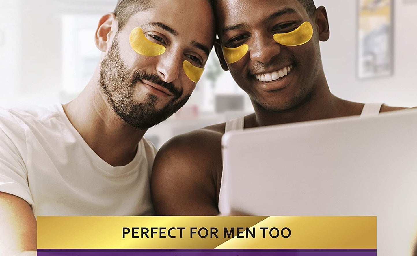 A couple wearing the gold under eye masks as they look at a tablet