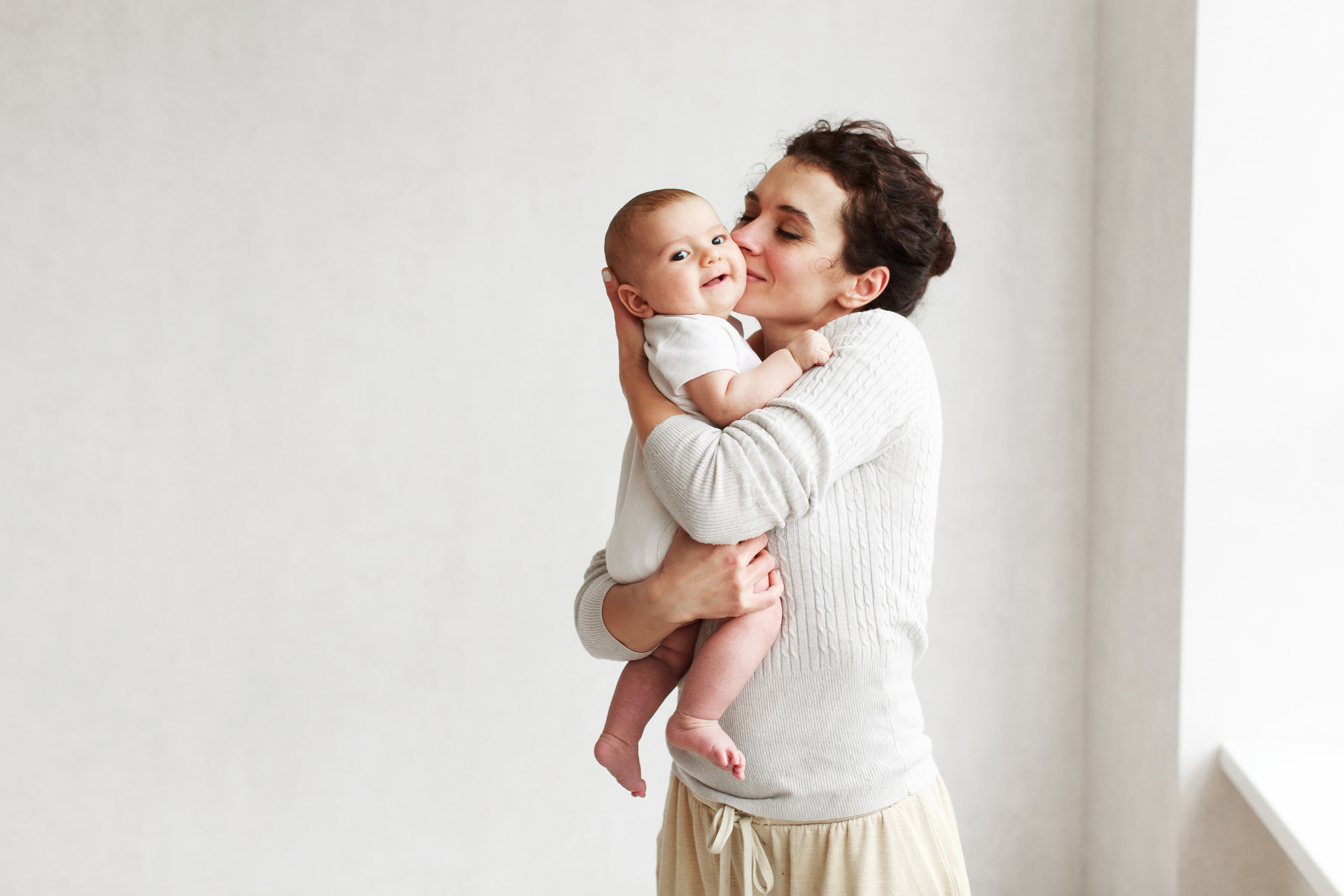 Woman with baby in a white room