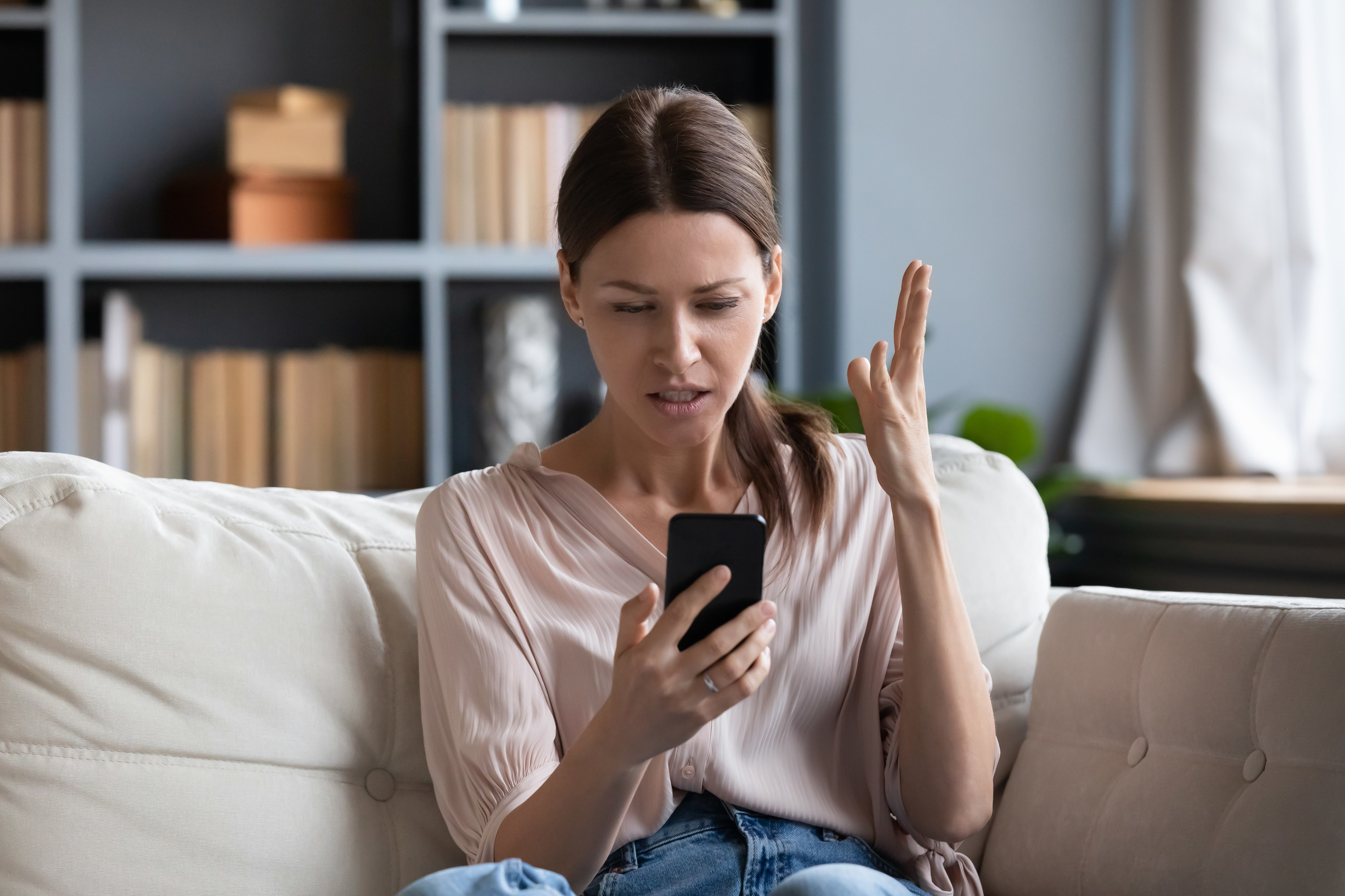 Woman looking at phone and feeling frusterated