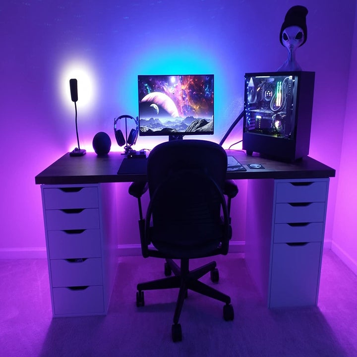 reviewer's desk setup with purple and blue backlighting around the desk and monitor