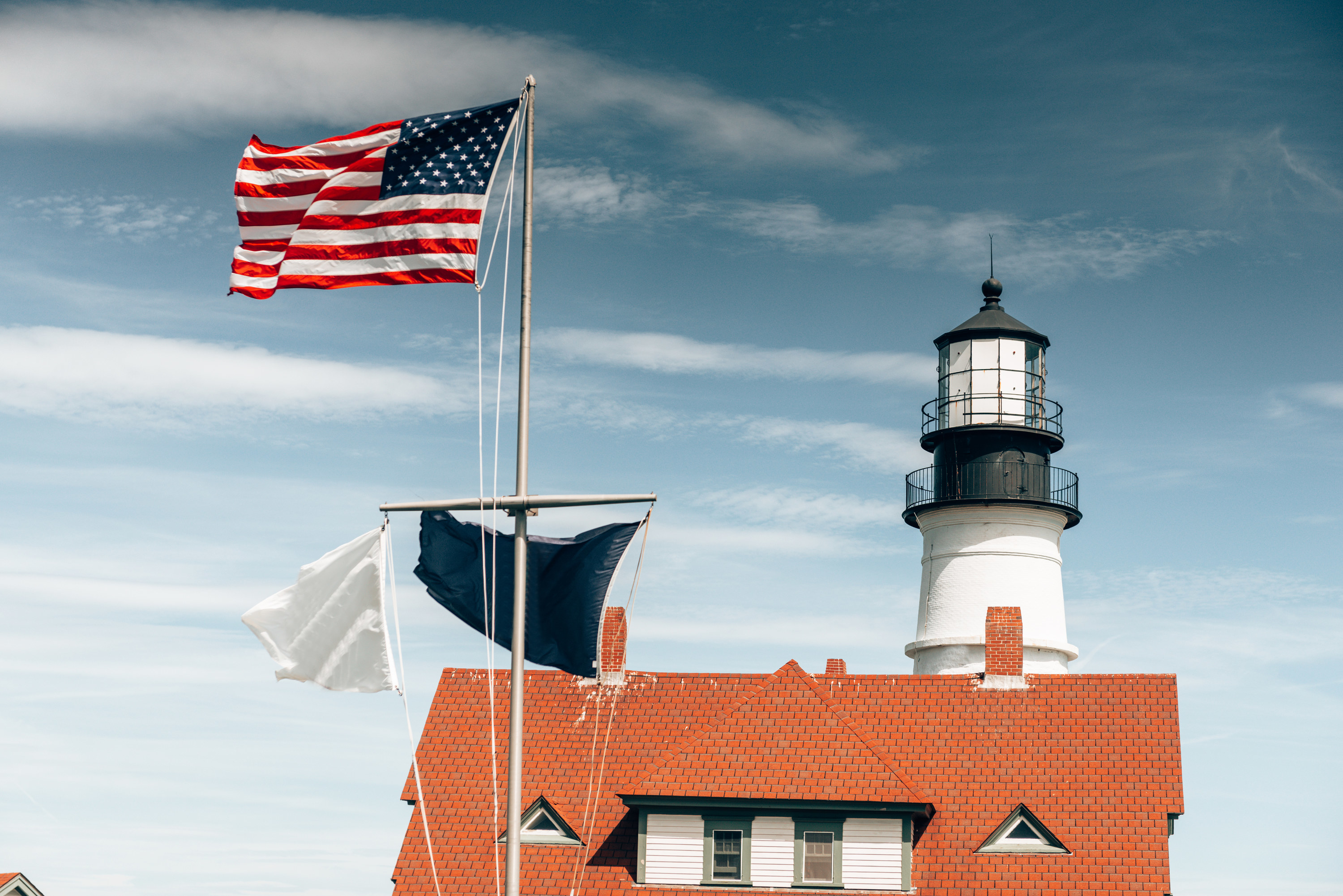 A lighthouse with a flying American flag