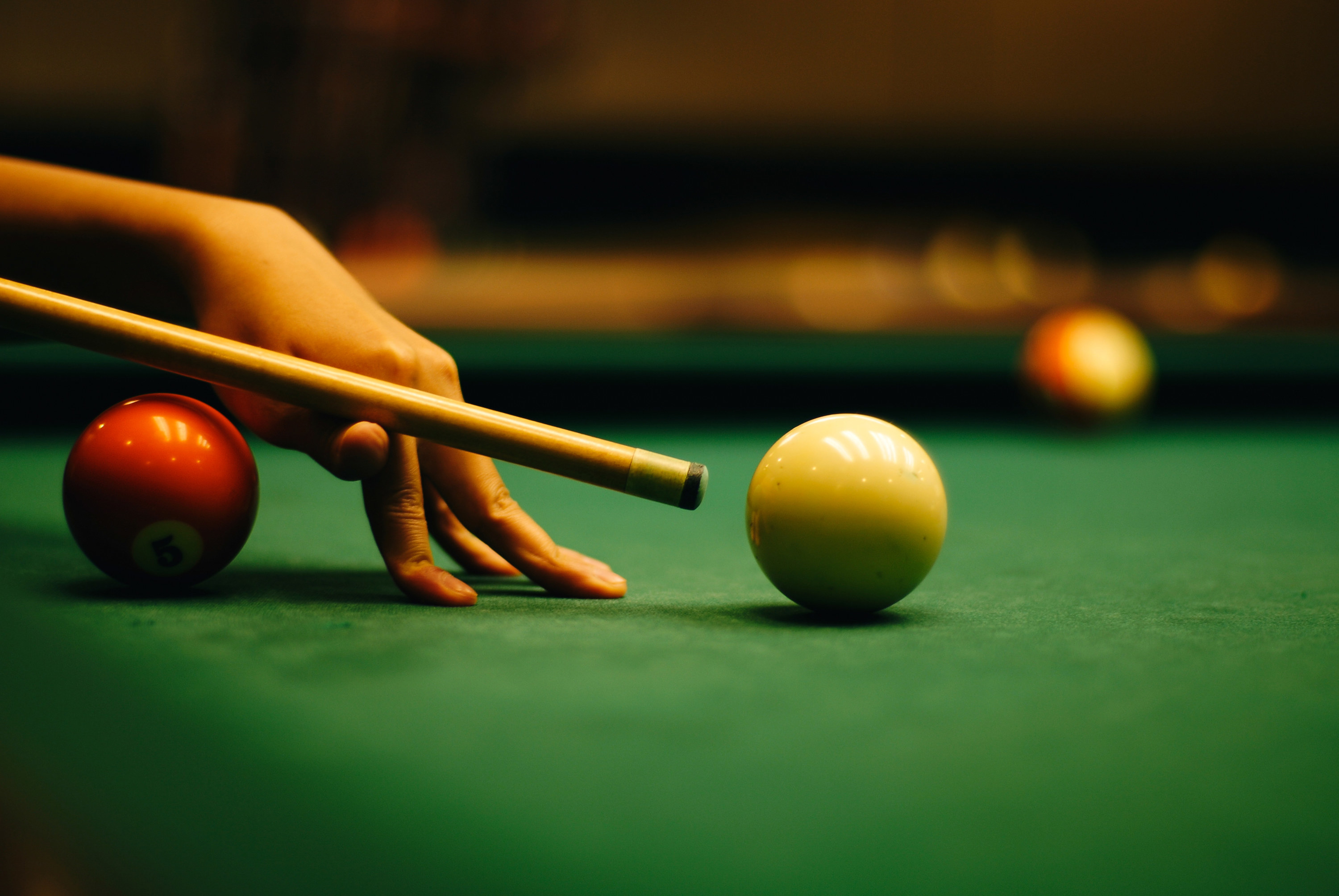 woman&#x27;s hand setting up a shot on a pool table