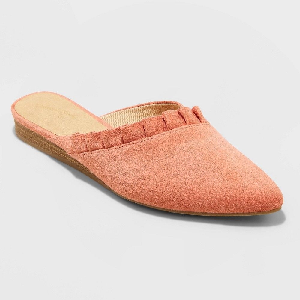 An orange mule with ruffle trim and a pointed-toe design