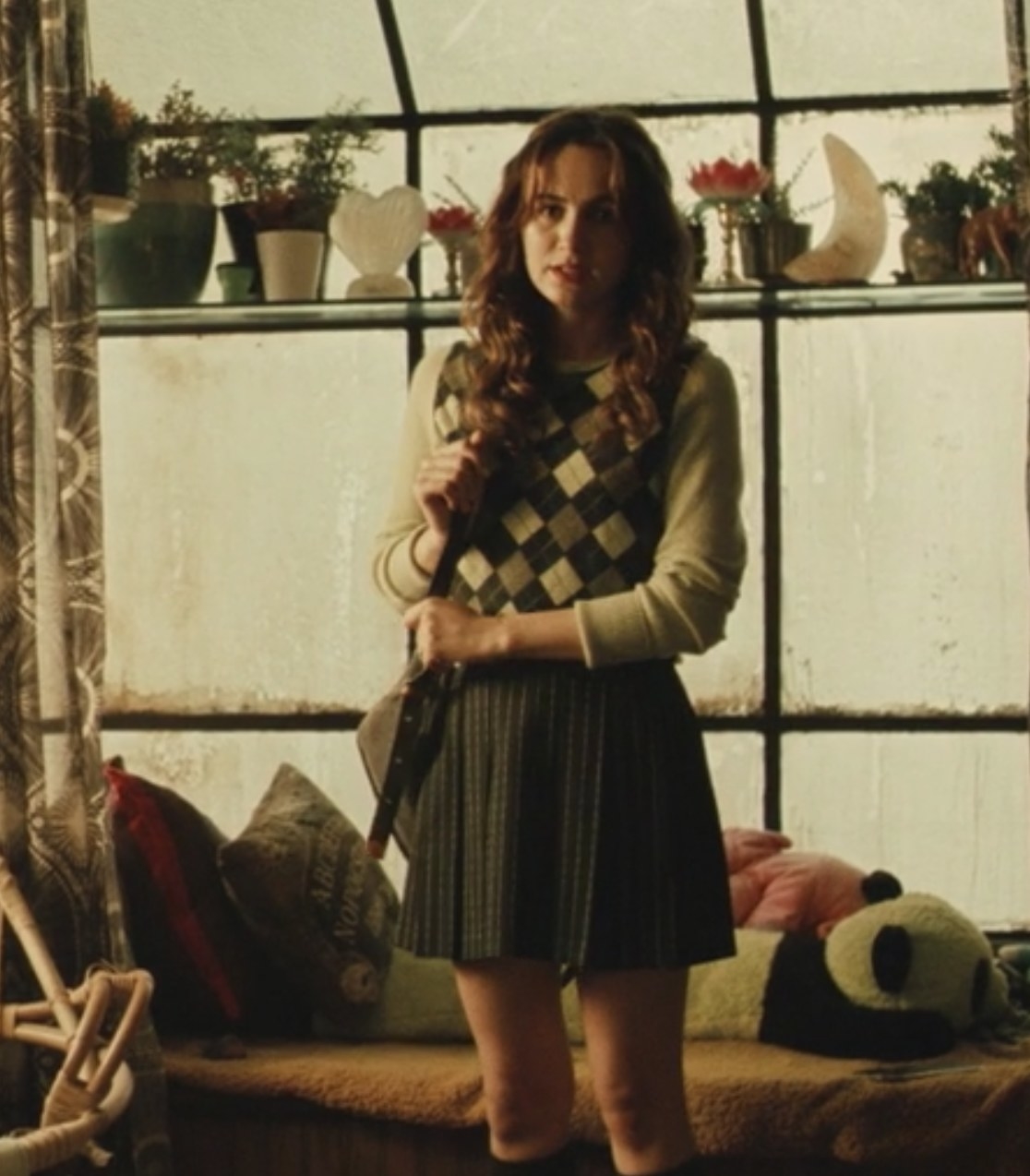 Lexi talks to Rue and wears a pleated skirt and argyle sweater