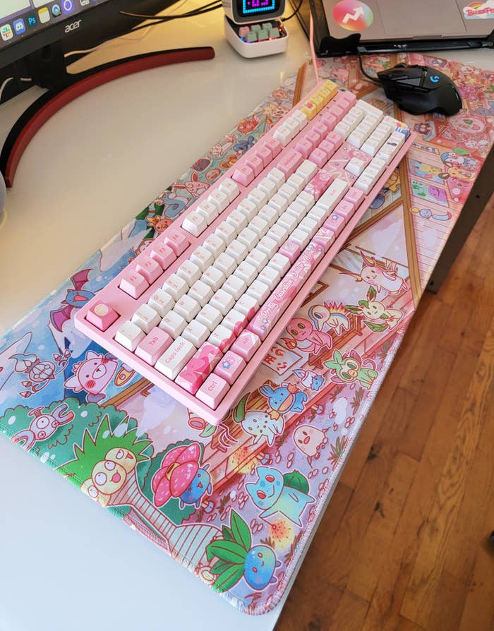 a pokemon-themed desk mat underneath a pink keyboard