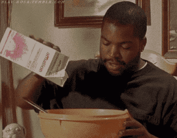 A man pouring milk into a giant cereal bowl.