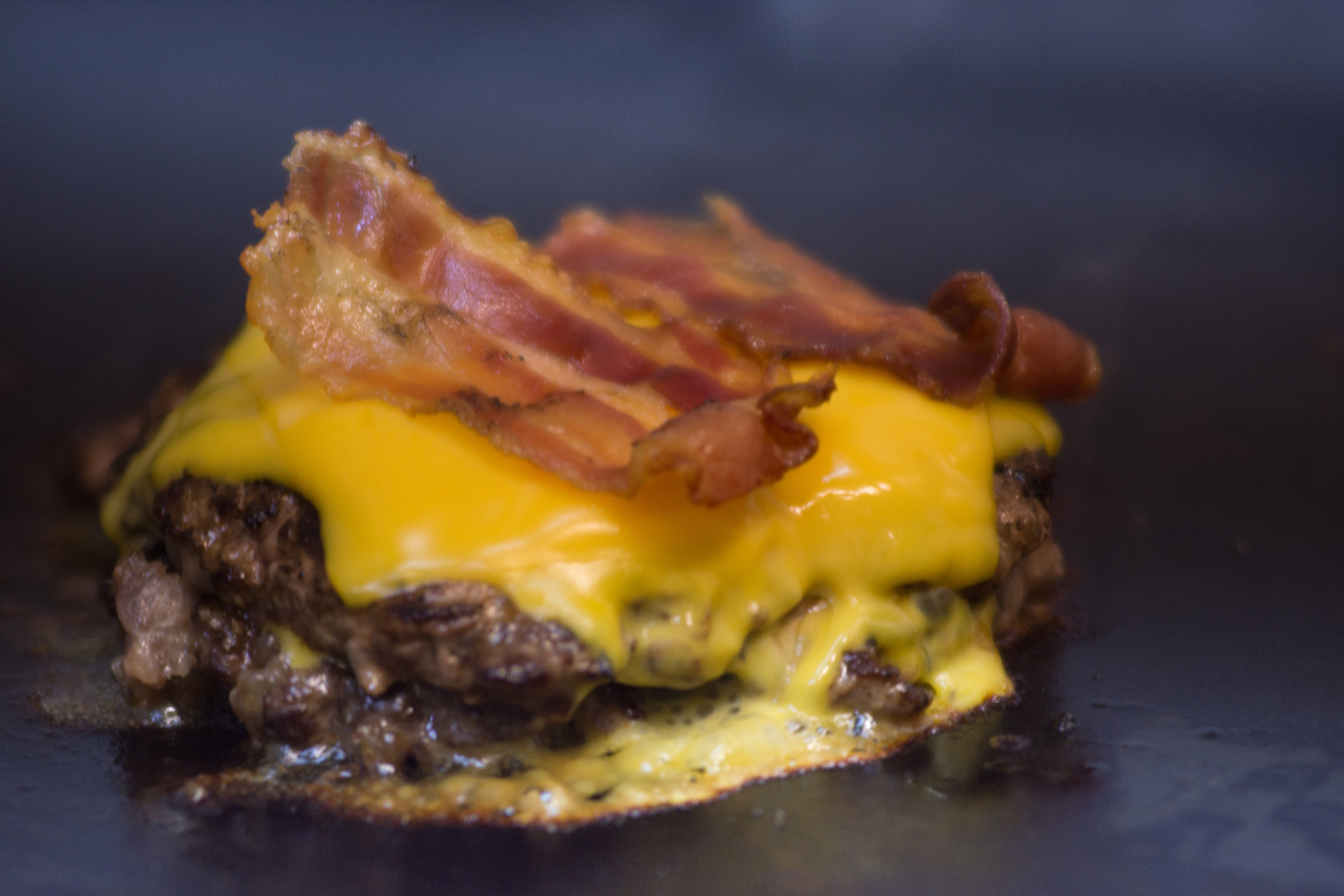 A burger patty with cheese and bacon.