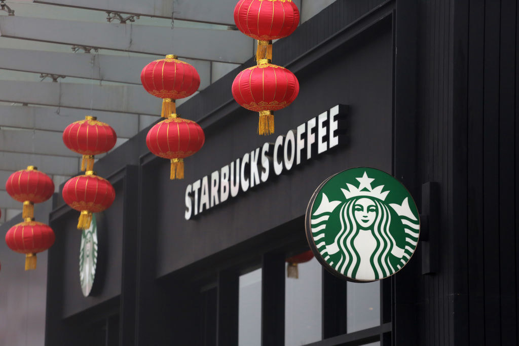 Red lanterns are seen decorated in front of a Starbucks Coffee store