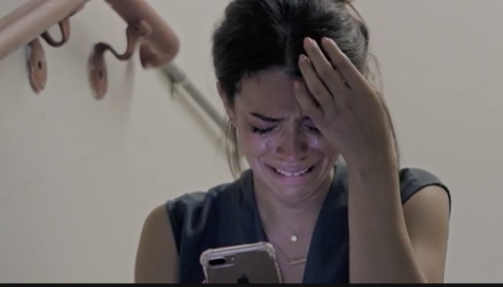 A woman crying while looking at a text message