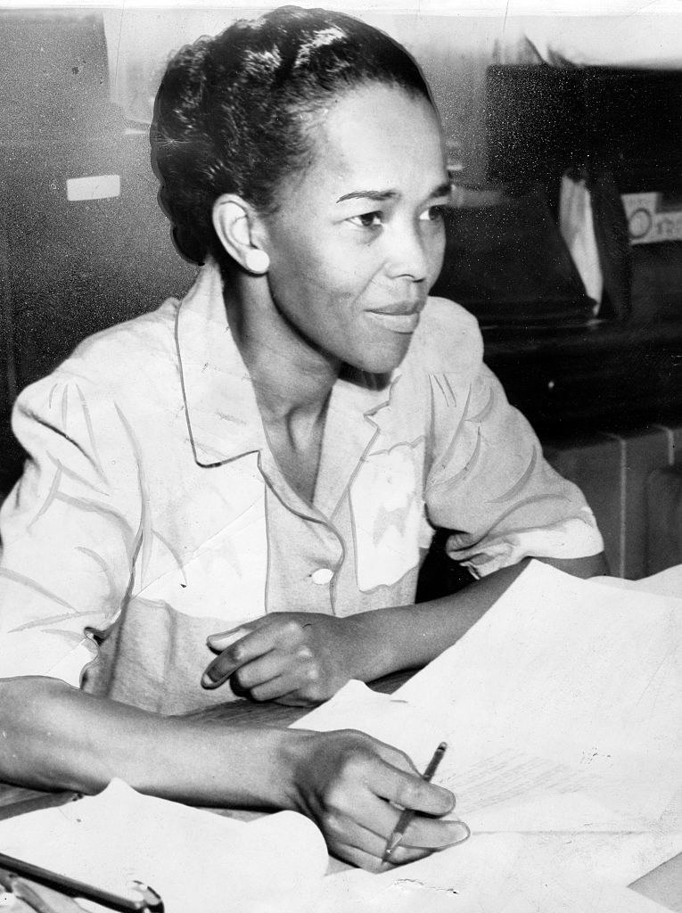 A Black woman looking over documents