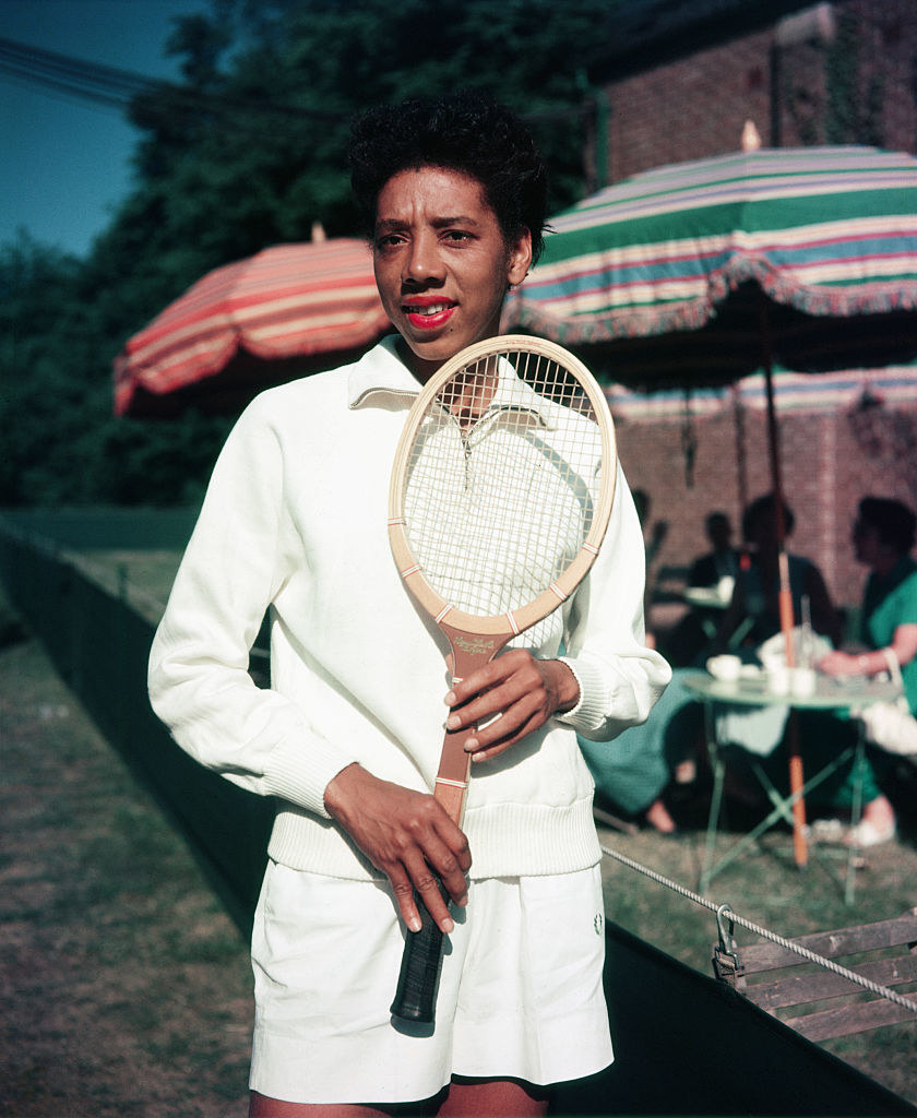 一位黑人妇女拿着网球拍