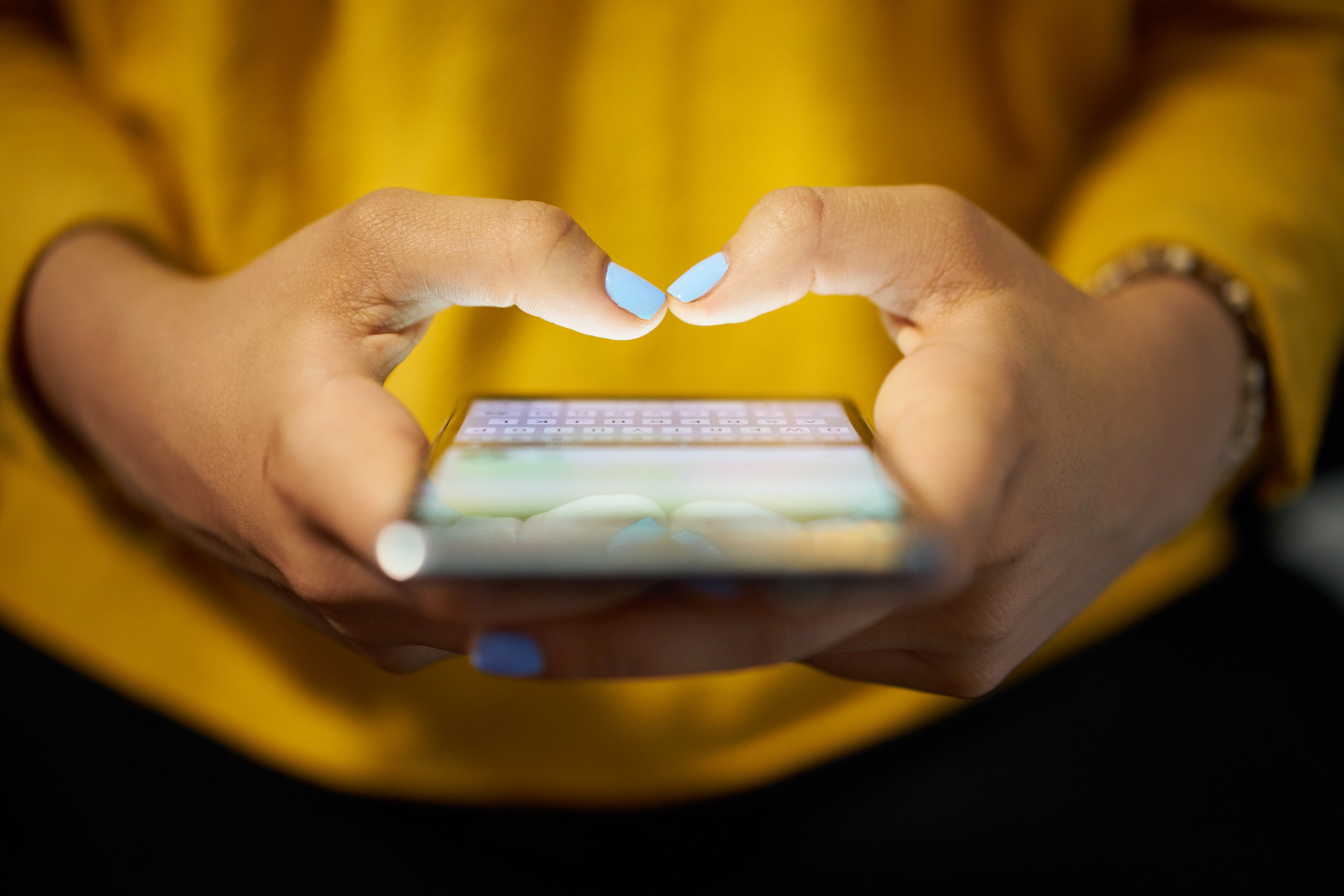 A stock image of hands holding a phone as they text