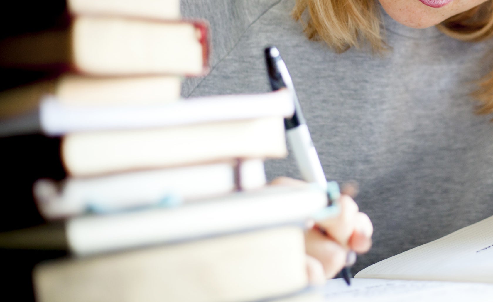 woman taking notes while studying