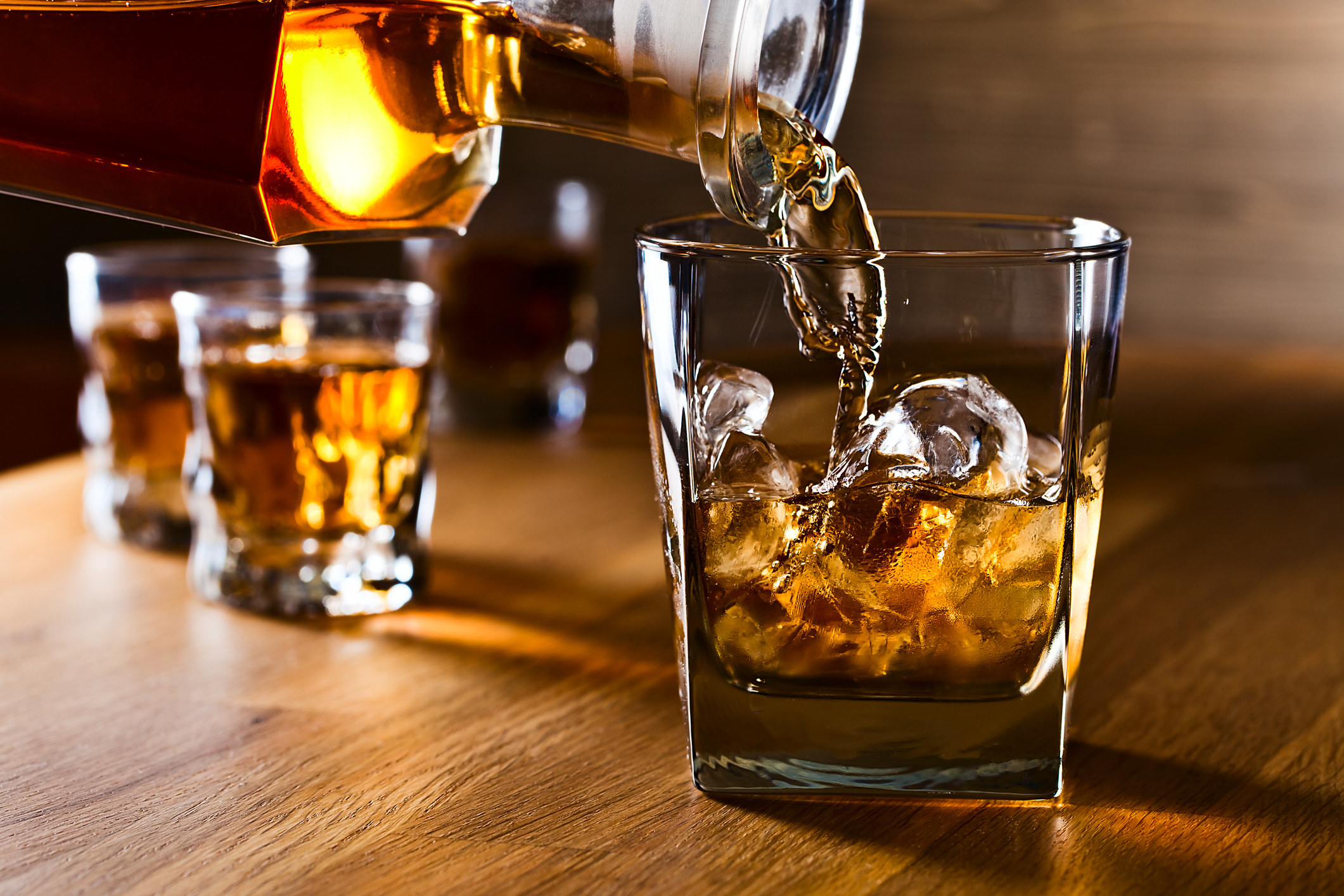 A stock image of whiskey and natural ice on old wooden table