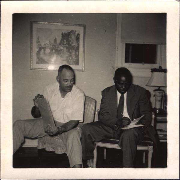 莱昂乔丹与身份不明的男子坐在一起记笔记