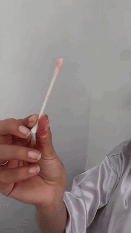 a gif of a model applying the drying lotion to acne on their face