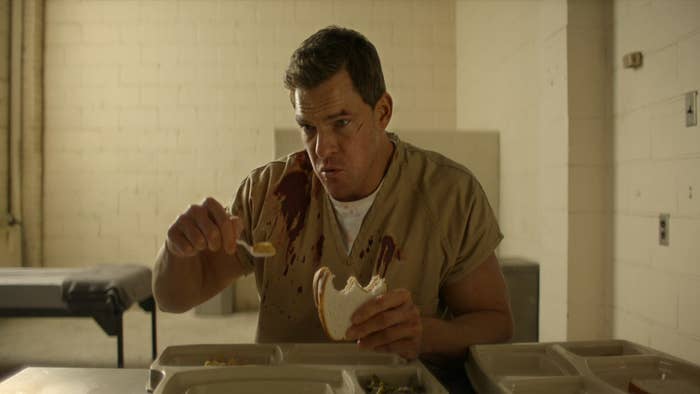 Jack Reacher eating food with a spoon in prison