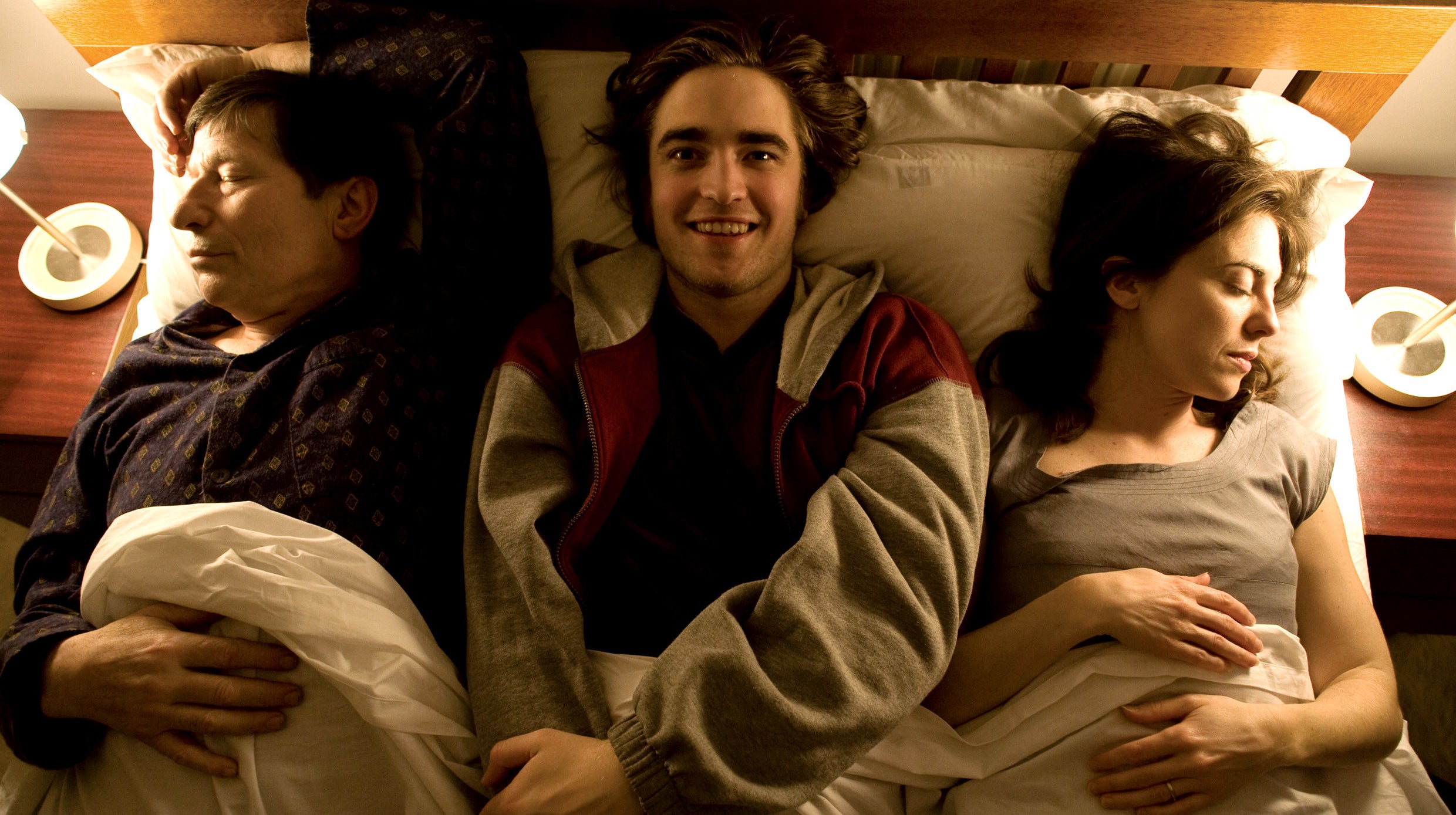 Robert Pattinson in bed with his parents on either side of him