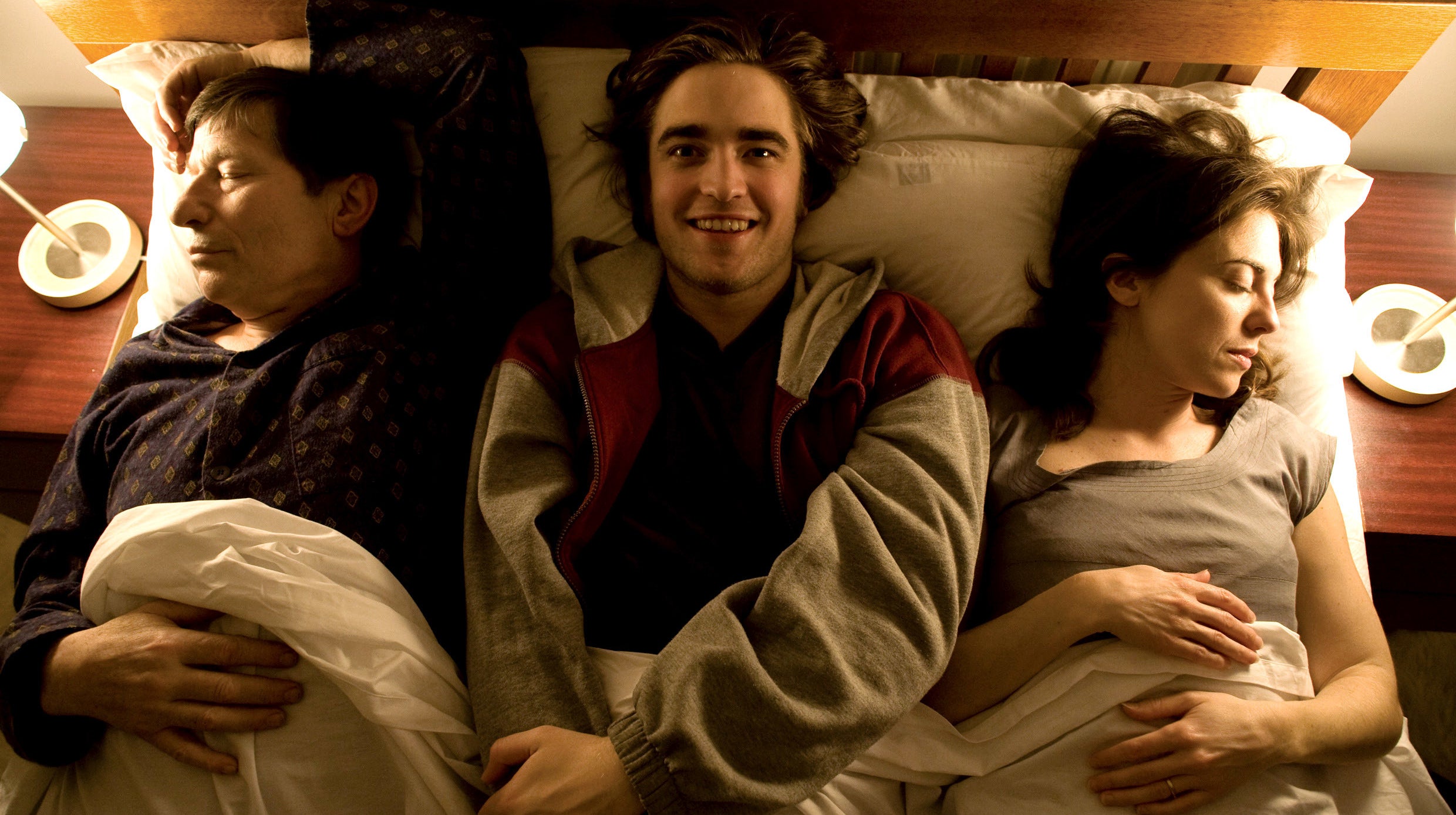 Robert Pattinson in bed with his parents on either side of him