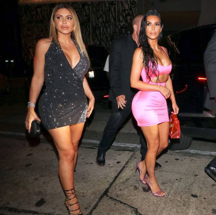 Larsa and Kim dressed up and walking down a sidewalk at night