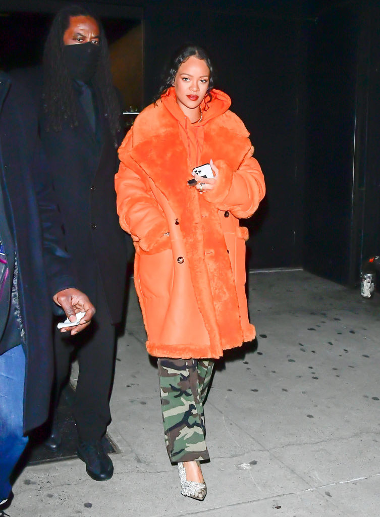 Rhianna walking outside in camo pants and a coat