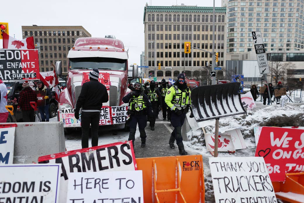 Police, protesters, trucks and many signs