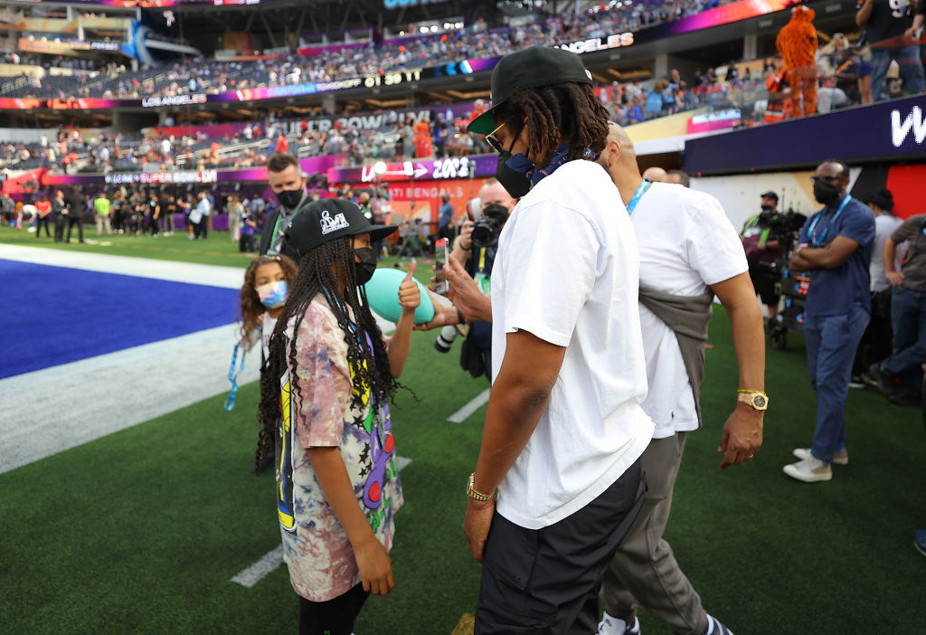 Blue Ivy and Jay Z on the field wearing masks