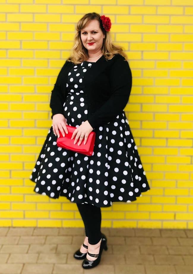 Reviewer photo in the black and white polka dot dress and a black cardigan