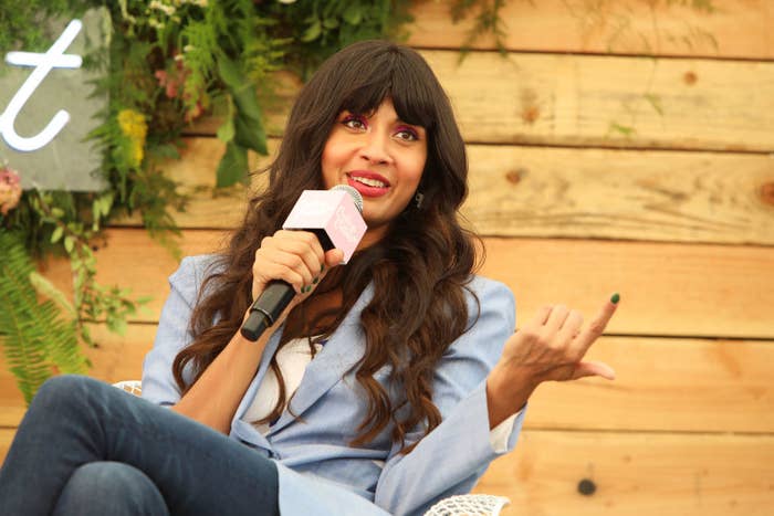 sitting on stage, Jamila speaks into a microphone