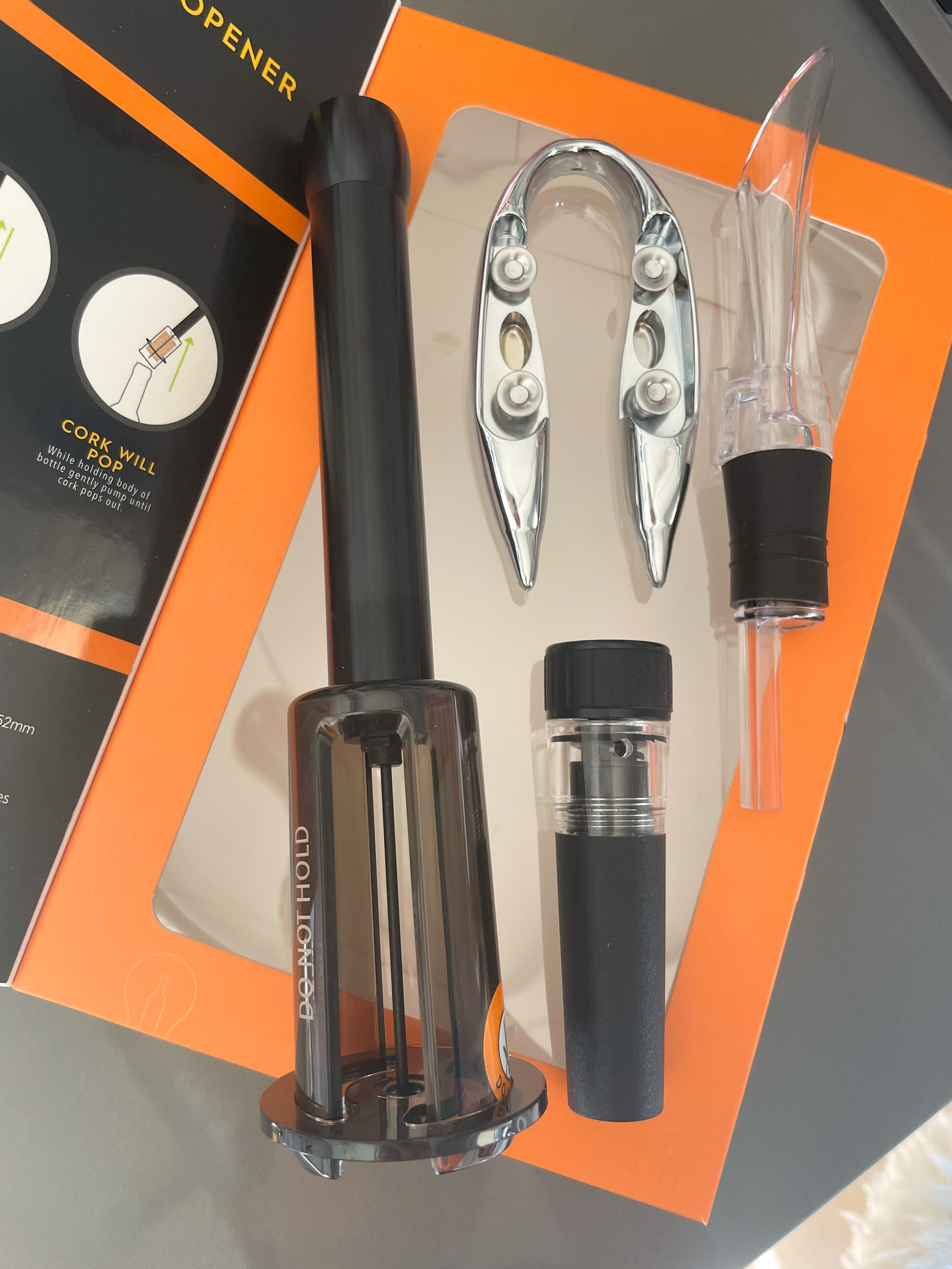 a four piece wine kit complete with pump opener, foil cutter, aerating spout and vacuum seal cap