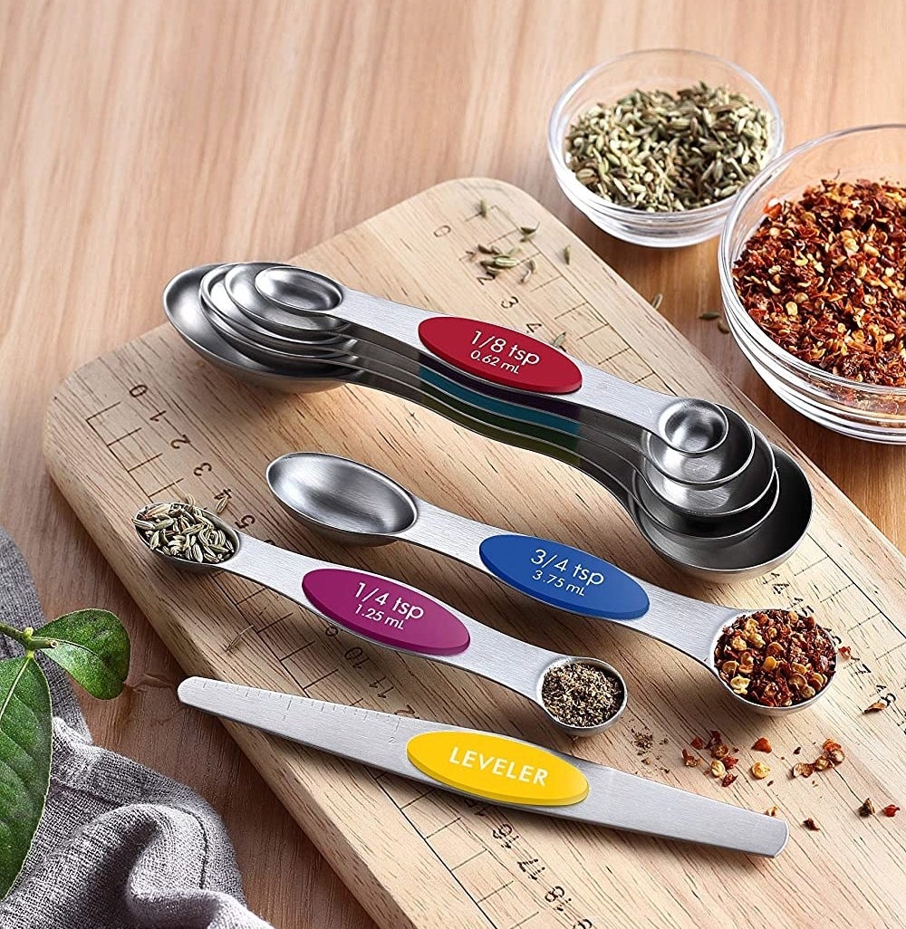 a set of double-ended measuring spoons filled with herbs and spices