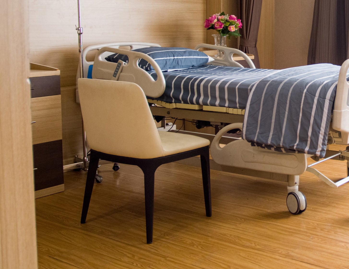 an empty chair faces a hospital bed in a hospital room