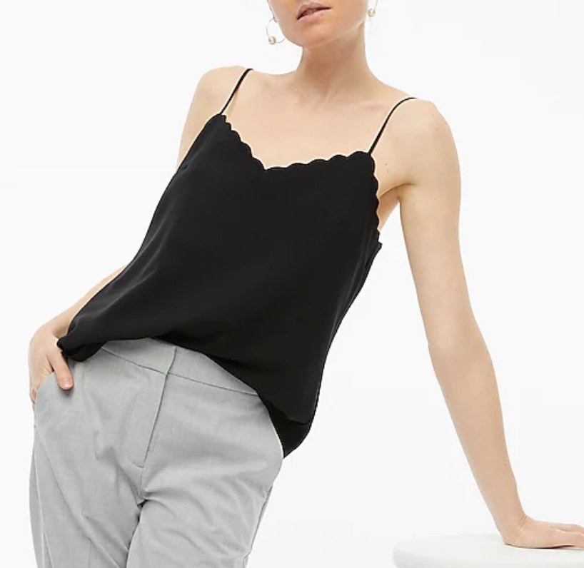 A model wearing a black scalloped cami top