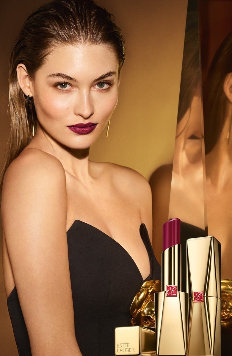 model wears dark berry Estée Lauder lipstick