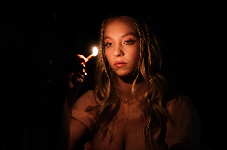 Sydney holding a lit match in the dark