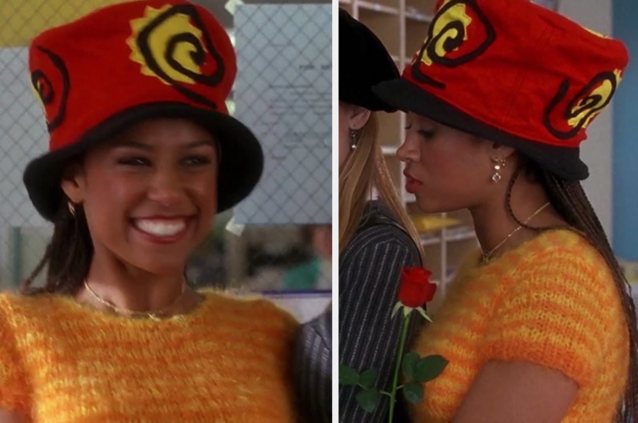 Dionne wears an orange fuzzy sweater with a bold hat at school