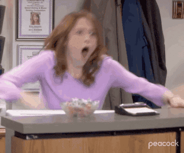 A gif of Erin from The Office standing up at her desk and cheering