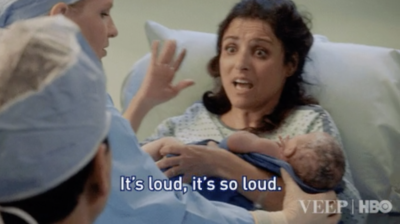 A woman looking stressed after giving birth saying &quot;it&#x27;s so loud!&quot;
