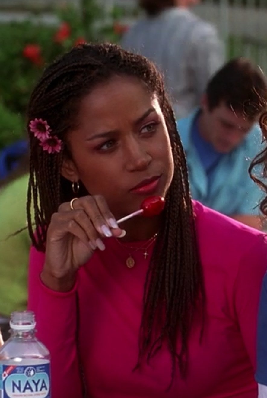 Dionne eats a lollipop at lunch while wearing a fuchsia top