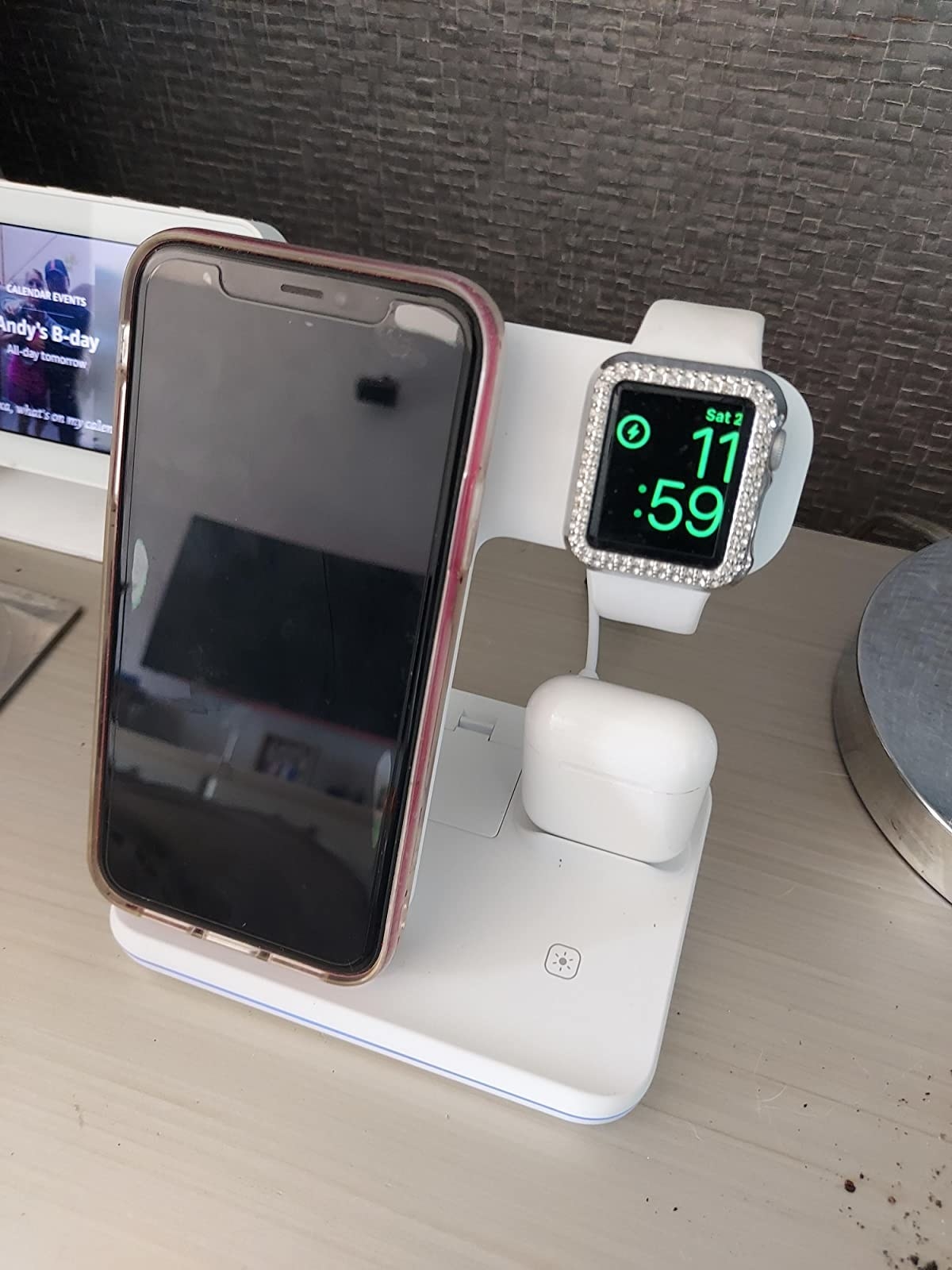 Reviewer photo of their iPhone, Apple Watch, and AirPods charging on the white wireless charger